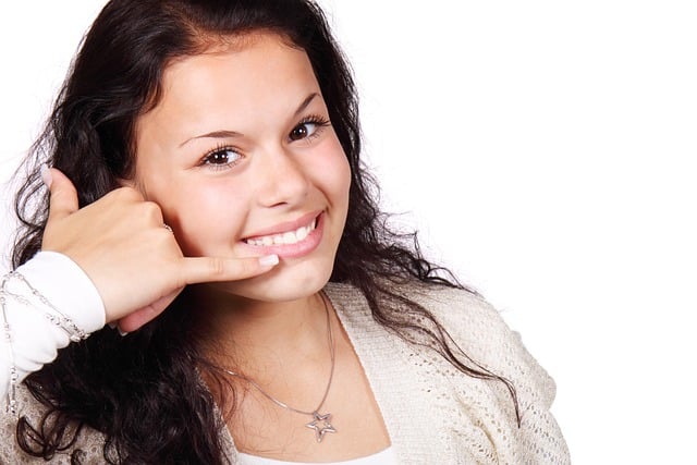 Young woman miming making a phone call with her hand